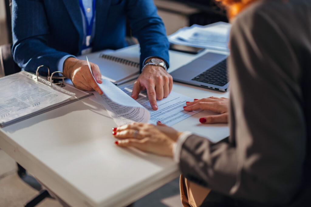 The real estate agent closes the deal with the client and they sign the contract